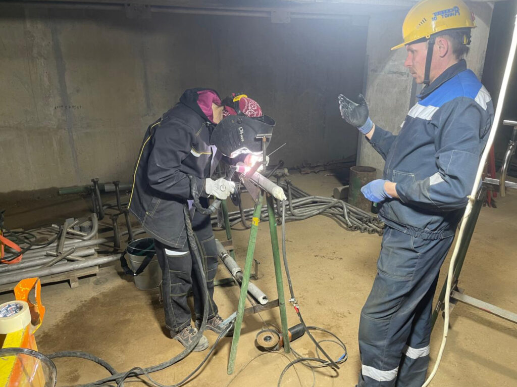 Два рабочих проводят сварочные работы в помещении Два рабочих проводят сварочные работы в помещении